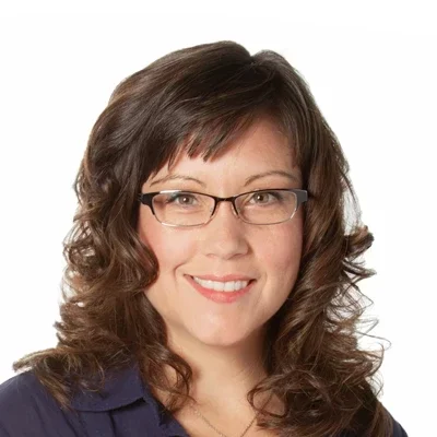 Lori smiling in a dark blue shirt.