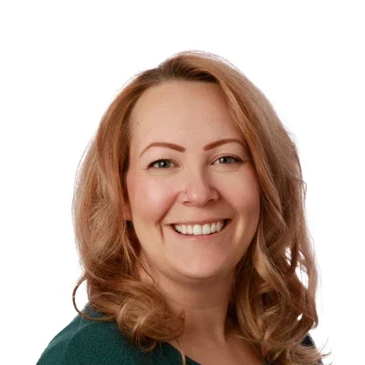 Miranda smiling, she has a green shirt on.